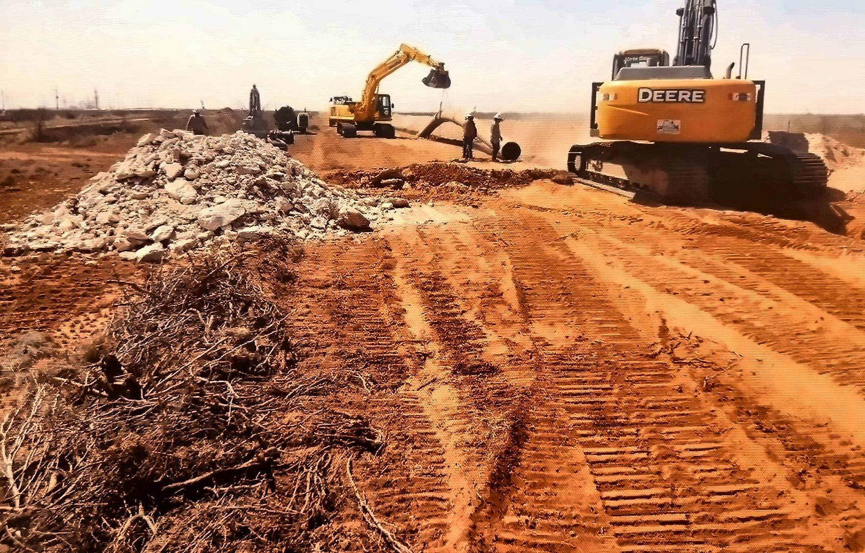 Pipeline right-of-way under construction with excavators in the Permian Basin
